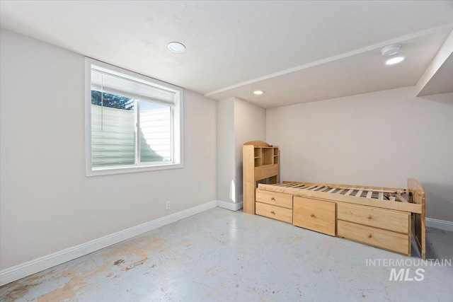 unfurnished bedroom featuring concrete floors, recessed lighting, and baseboards