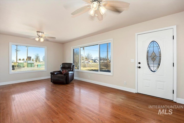 foyer with ceiling fan, wood finished floors, and baseboards