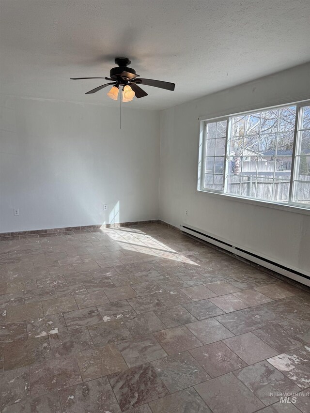 1850 18th Circle Dr, Heyburn, ID 83336 - empty room featuring plenty of natural light, a baseboard heating unit, ceiling fan, and baseboards