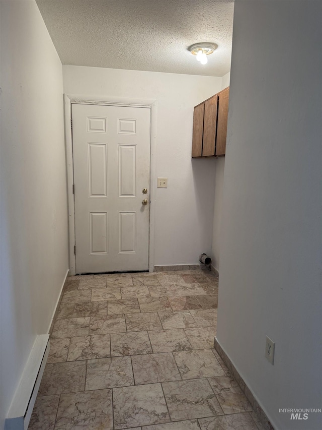 1850 18th Circle Dr, Heyburn, ID 83336 - washroom featuring a textured ceiling, baseboards, and a baseboard radiator