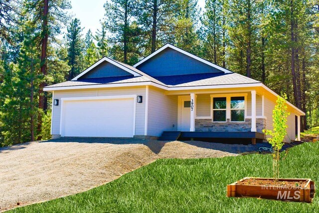 3907 Ponderosa Ct, New Meadows, ID 83654 - view of front facade with dirt driveway, a garage, a porch, and stone siding
