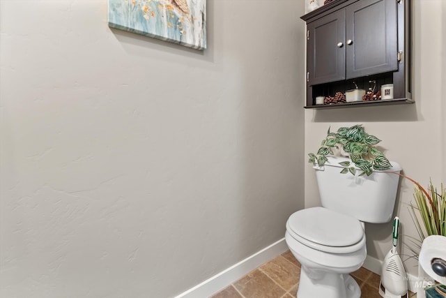 bathroom featuring baseboards and toilet