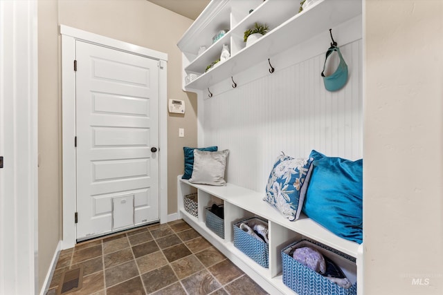 mudroom featuring dark stone finish flooring and baseboards