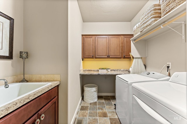 laundry area with washer and dryer, cabinet space, baseboards, and light stone finish flooring