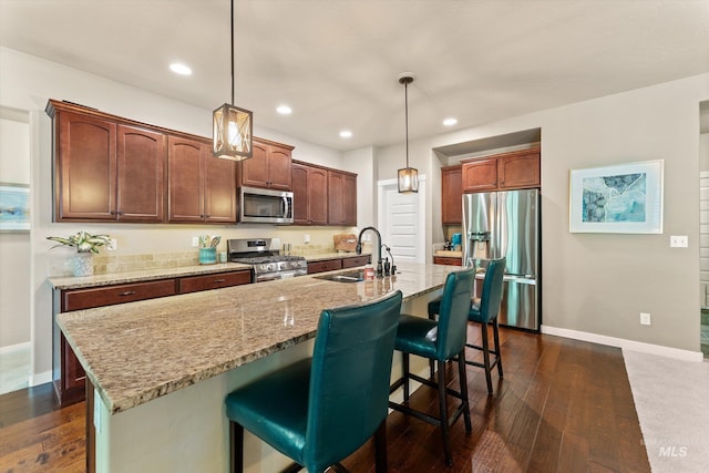 kitchen with appliances with stainless steel finishes, a sink, baseboards, dark wood-type flooring, and recessed lighting