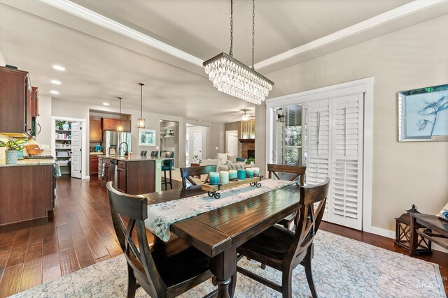 dining space with dark wood-type flooring, a chandelier, ornamental molding, recessed lighting, and baseboards