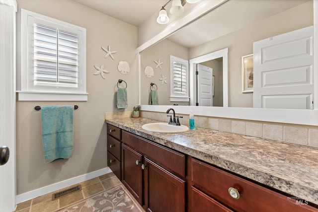bathroom with baseboards, vanity, and tile patterned flooring