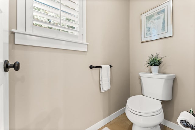 bathroom with baseboards, toilet, and tile patterned floors