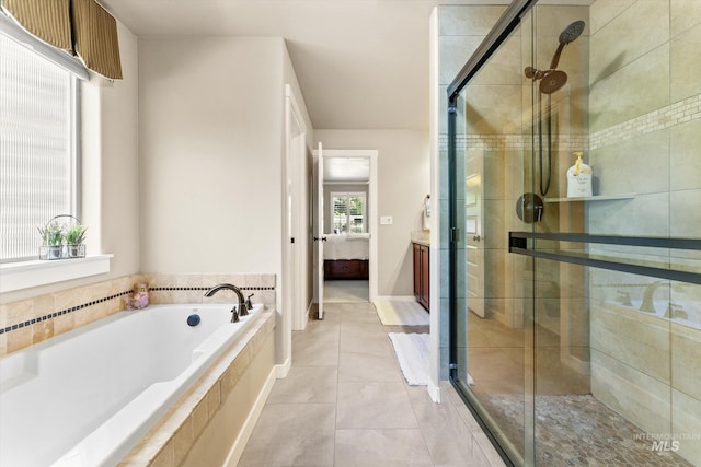 ensuite bathroom with a stall shower, a garden tub, vanity, and tile patterned flooring