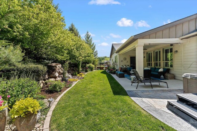 view of green lawn featuring a patio area and an outdoor hangout area