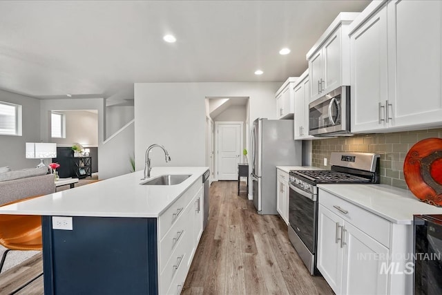 4084 E Esperanto St, Meridian, ID 83642 - kitchen with an island with sink, light countertops, a sink, stainless steel appliances, and backsplash