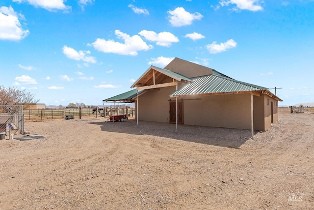 11 W 300 S, Burley, ID 83318 - back of house featuring an exterior structure, a standing seam roof, metal roof, a rural view, and stucco siding