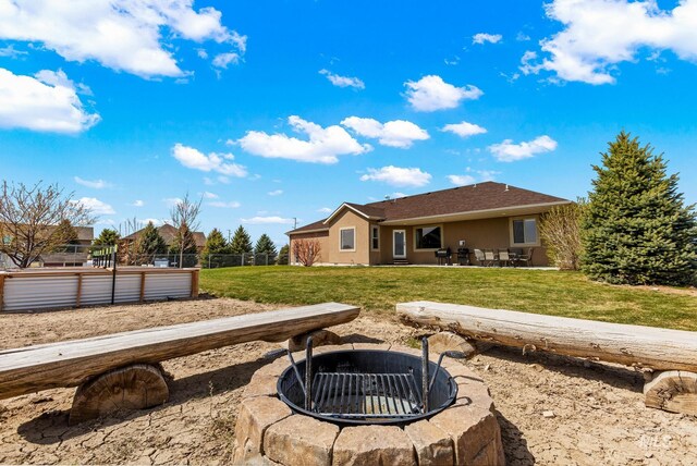 11 W 300 S, Burley, ID 83318 - back of property featuring fence, stucco siding, a patio, a lawn, and a fire pit