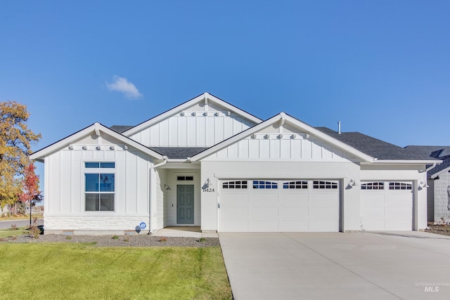 view of front of home featuring an attached garage, driveway, a shingled roof, and board and batten siding