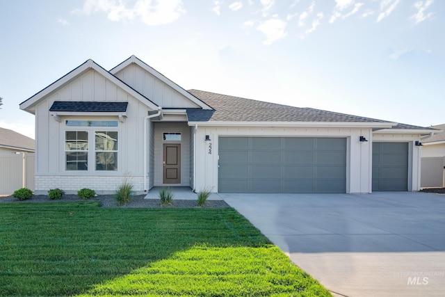view of front facade with roof with shingles, concrete driveway, a garage, a front yard, and board and batten siding