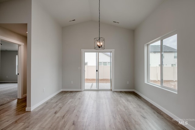unfurnished dining area with light wood-style flooring, a wealth of natural light, a notable chandelier, and visible vents