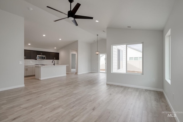 unfurnished living room with lofted ceiling, recessed lighting, and plenty of natural light
