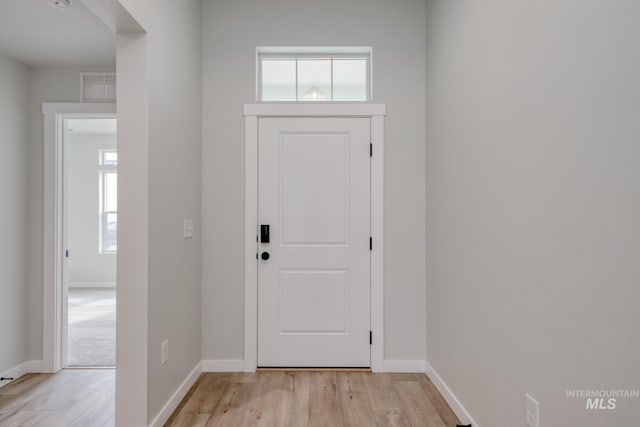 entryway with a wealth of natural light, visible vents, and light wood-style floors
