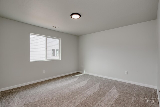 unfurnished room with carpet, baseboards, and visible vents