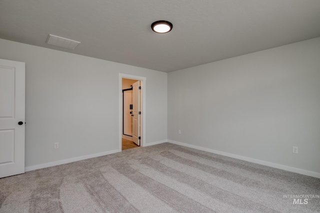 carpeted empty room with visible vents and baseboards