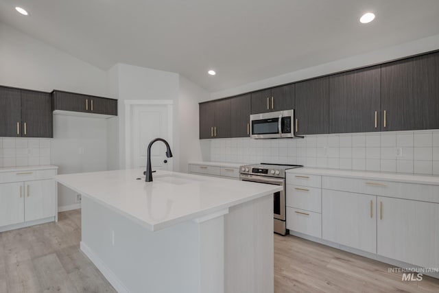 kitchen featuring a sink, stainless steel appliances, light countertops, and light wood-type flooring
