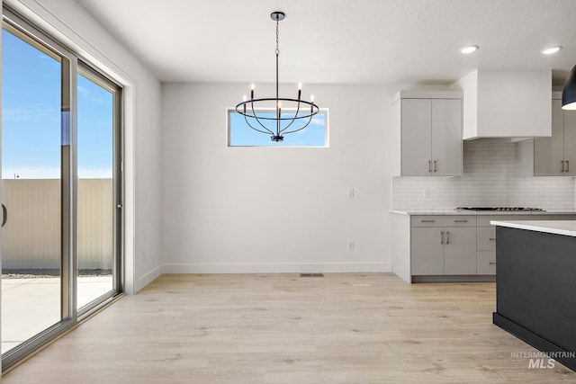 1700 Black Elm, Star, ID 83669 - kitchen with gray cabinets, backsplash, a chandelier, light countertops, and light wood-style floors
