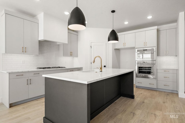 1700 Black Elm, Star, ID 83669 - kitchen featuring stainless steel double oven, light wood-type flooring, gas stovetop, decorative backsplash, and light stone countertops
