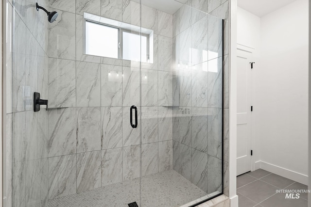 full bathroom featuring baseboards, tile patterned flooring, and a stall shower