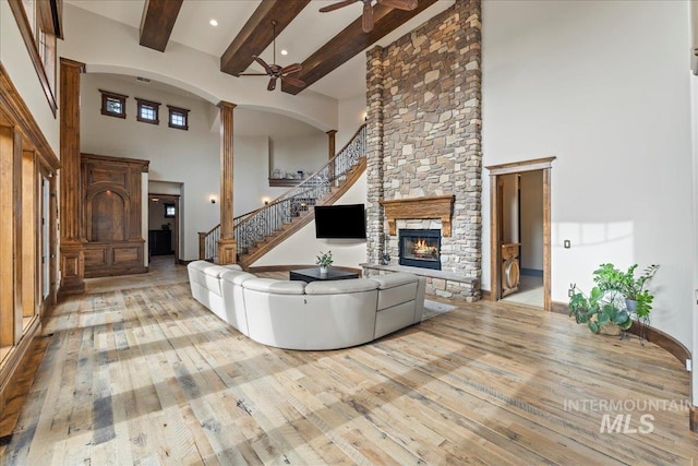 7600 W Ledgerwood Ln, Meridian, ID 83646 - living area featuring a high ceiling, beam ceiling, a ceiling fan, a stone fireplace, and hardwood / wood-style flooring