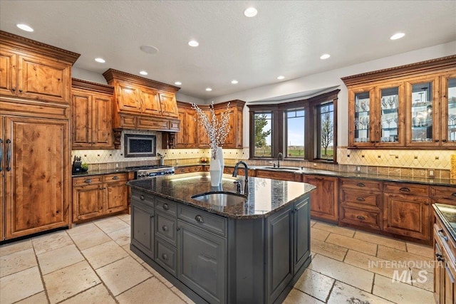 7600 W Ledgerwood Ln, Meridian, ID 83646 - kitchen featuring stone tile flooring, brown cabinets, recessed lighting, and a sink