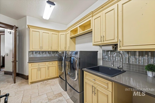 7600 W Ledgerwood Ln, Meridian, ID 83646 - clothes washing area featuring a sink, stone tile flooring, baseboards, washer and clothes dryer, and cabinet space