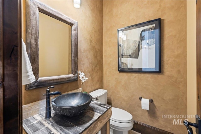 7600 W Ledgerwood Ln, Meridian, ID 83646 - half bath featuring a textured wall, toilet, baseboards, and a sink
