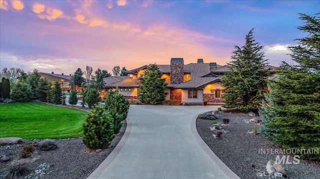 7600 W Ledgerwood Ln, Meridian, ID 83646 - view of front facade with a lawn, a tiled roof, a chimney, stucco siding, and curved driveway