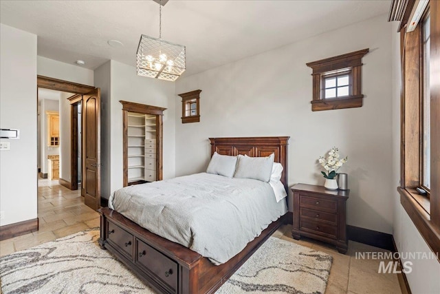 7600 W Ledgerwood Ln, Meridian, ID 83646 - bedroom with stone tile floors, a chandelier, and baseboards