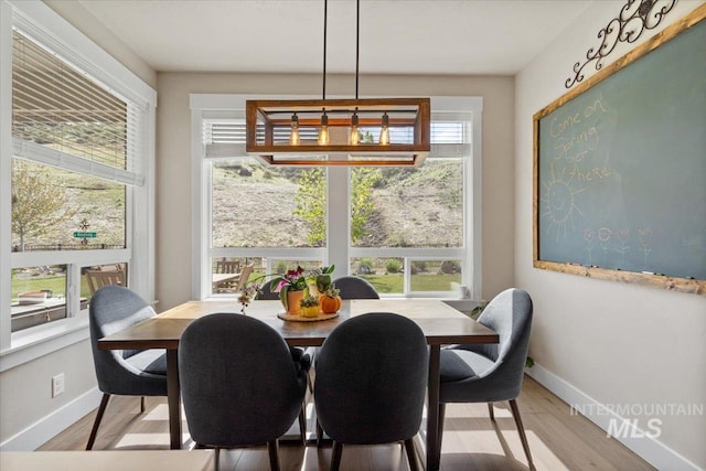 dining area featuring light wood-type flooring and baseboards