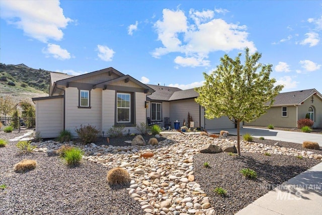 ranch-style house featuring a garage, fence, and concrete driveway