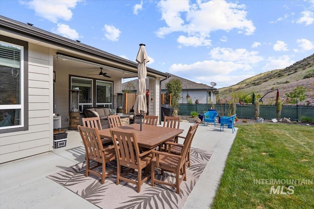 view of patio / terrace featuring a ceiling fan, a mountain view, fence, and an outdoor hangout area