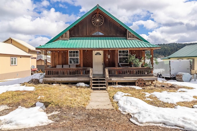 107 N 1st St, Elk River, ID 83827 - chalet / cabin with metal roof, board and batten siding, and covered porch