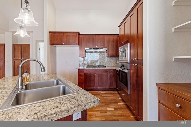 1148 E Winding Creek Dr, Eagle, ID 83616 - kitchen featuring light wood-style flooring, stainless steel appliances, under cabinet range hood, light countertops, and a sink