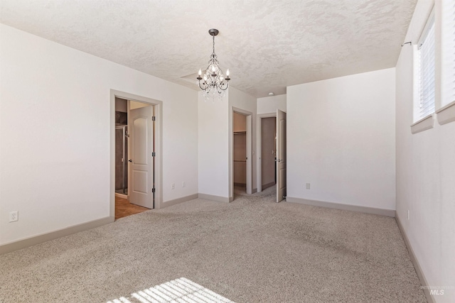 1148 E Winding Creek Dr, Eagle, ID 83616 - carpeted empty room with a textured ceiling, an inviting chandelier, and baseboards