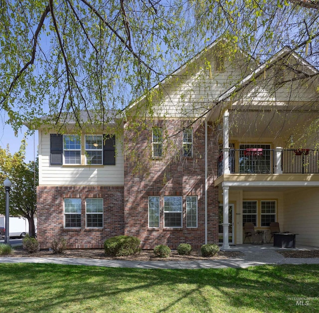 1148 E Winding Creek Dr, Eagle, ID 83616 - exterior space with a lawn, a patio area, a balcony, and brick siding
