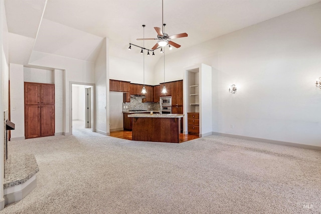 1148 E Winding Creek Dr, Eagle, ID 83616 - kitchen with stainless steel microwave, carpet, ceiling fan, a high ceiling, and open floor plan