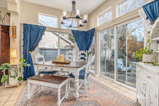 dining area with an inviting chandelier, a healthy amount of sunlight, and tile patterned floors