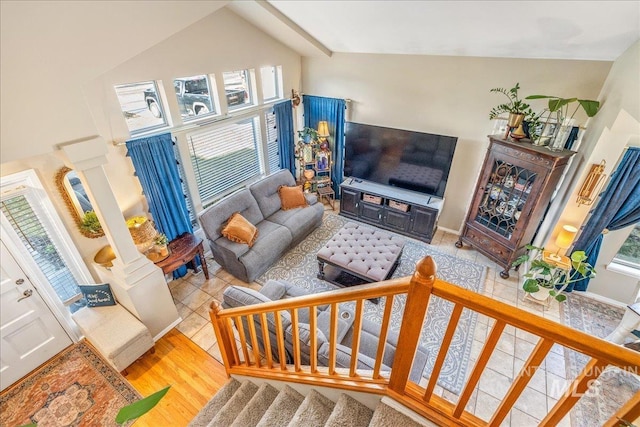 living area featuring high vaulted ceiling, stairs, and wood finished floors