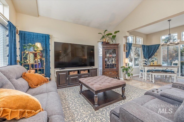 tiled living room featuring baseboards, high vaulted ceiling, and an inviting chandelier