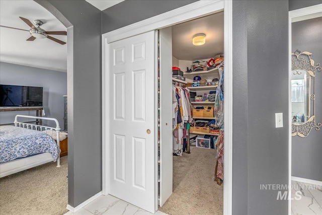 interior space with marble finish floor, carpet floors, and ceiling fan