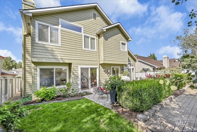 back of property with a yard, a patio, and fence