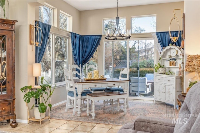 tiled dining room featuring baseboards and a chandelier