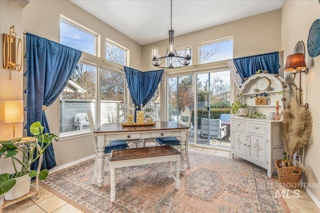 dining area featuring an inviting chandelier, light tile patterned flooring, and baseboards