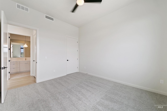 unfurnished bedroom featuring light carpet, visible vents, a ceiling fan, and baseboards